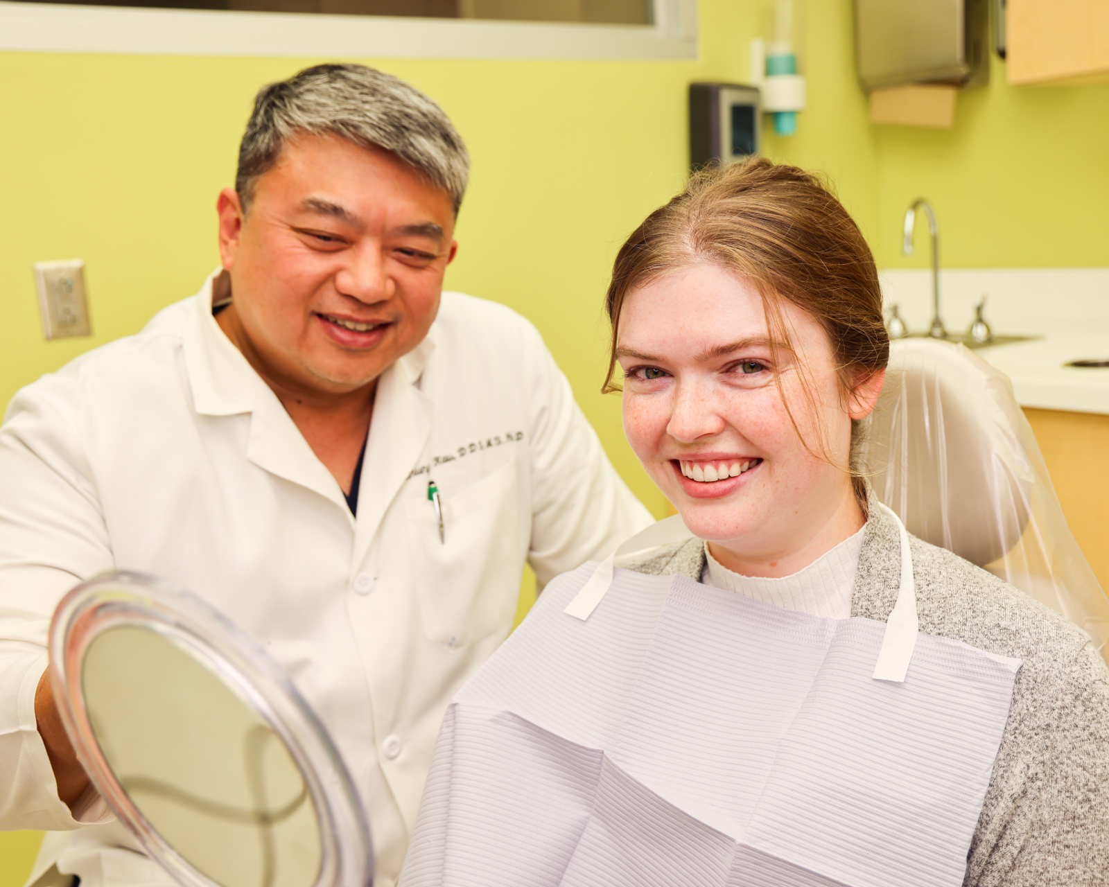 Faculty showing patient their smile after braces